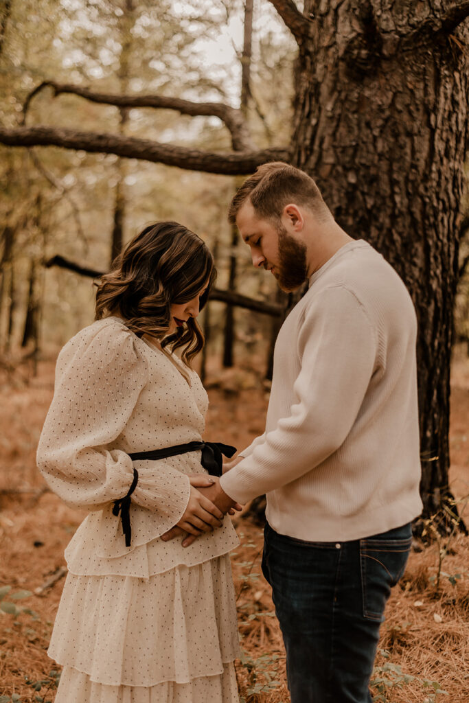 pregnancy announcement photos in a pine tree forest