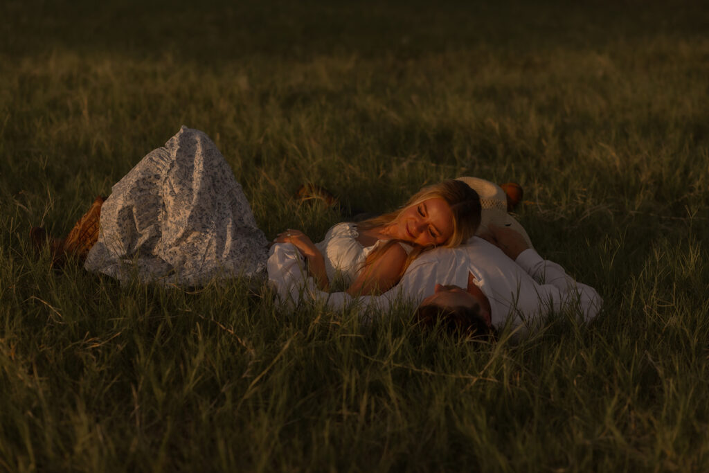 engagement couple laying in grass